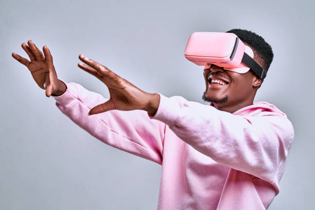 istock Young african american man playing virtual reality game using goggles 1244137920