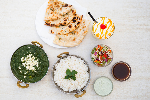 Authentic indian vegetarian dish Palak Paneer with rice and naan bread.
