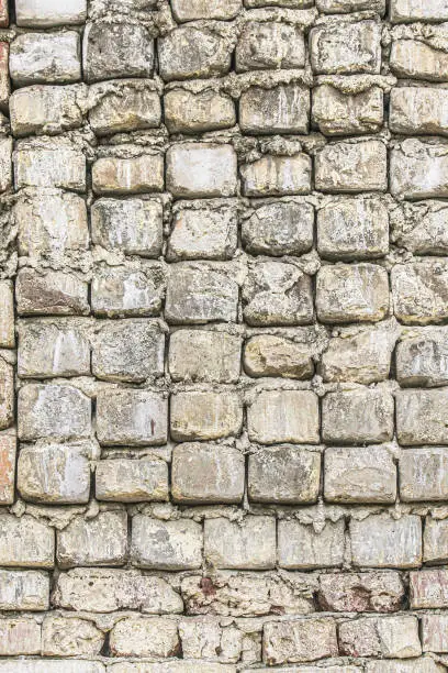 Photo of Background of an old and ruined white brick wall.