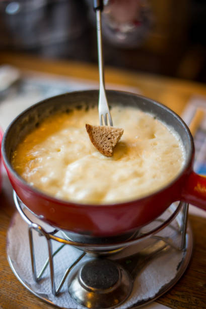 fondue suisse de fromage sur la table de salle à manger - fondue fork photos et images de collection