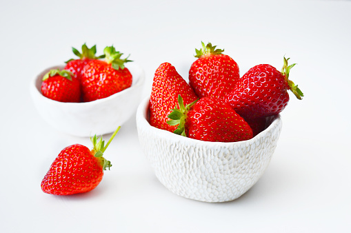 strawberries in a bowl isolated on white