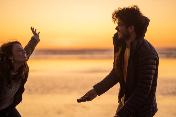 Friends chat and laugh on the beach at sunrise