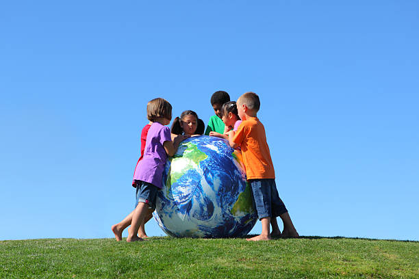 istock Group of multi-ethnic kids looking at large earth ball 124428364
