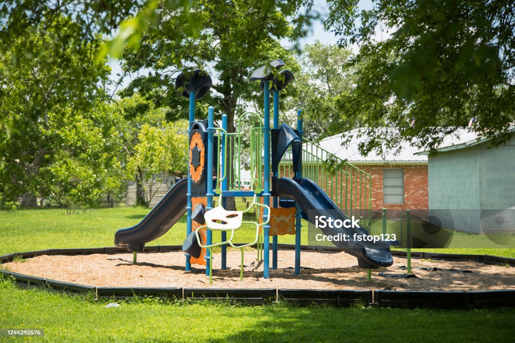 Empty school or neighborhood park playground. Empty playground equipment at school or neighborhood park.  No people.  COVID-19, loneliness, child abuse, childhood, education concepts. Childhood Stock Photo