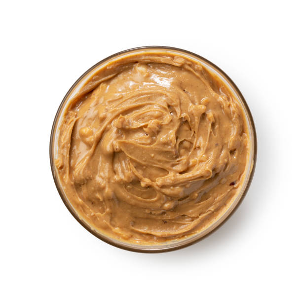 istock Peanut butter in a glass bowl set against a white background. 1244329906