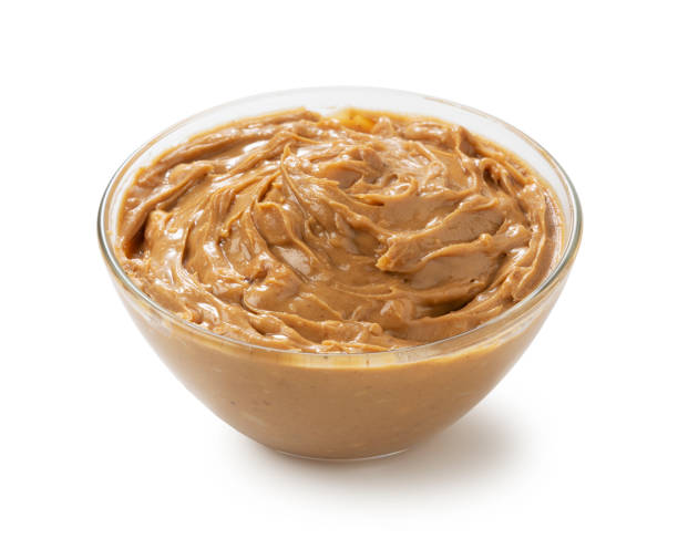 istock Peanut butter in a glass bowl set against a white background. 1244336949