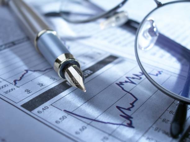istock Fountain pen and glasses on stock chart. 124435300