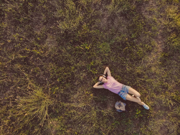 frau entspannt auf wiese - tranquil scene joy vacations high angle view stock-fotos und bilder