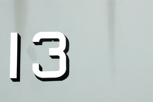 The ominous number 13 on gray metal background.