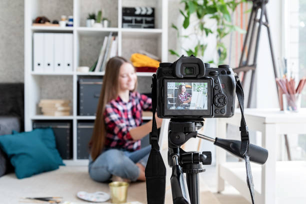 istock Woman making a video for her blog on art using a tripod mounted digital camera 1244392485