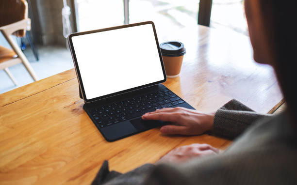 istock a businesswoman using and touching on tablet touchpad with blank white desktop screen as computer pc with coffee cup on the table 1244417974