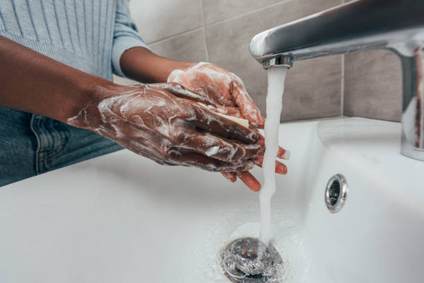 vista ritagliata di donna afroamericana lavarsi le mani con sapone - lavarsi le mani foto e immagini stock