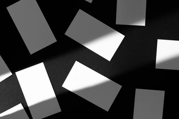 istock Blank businesscards on black background. Creative photo with shadows 1244454131