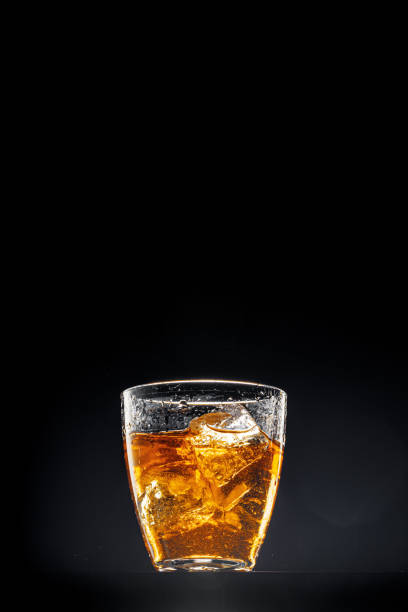 istock Glass of whisky on black background, copy space 1244459982