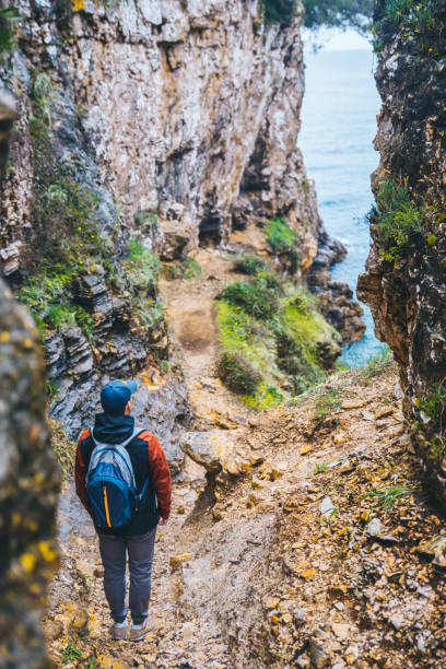 istock man with backpack at footpath canyon leading to sea beach 1244466966