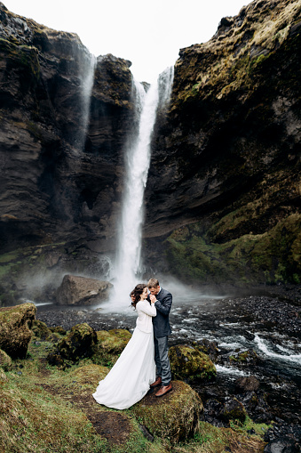 Destino de la boda de Islandia, cerca de la cascada de Kvernufoss. La pareja de bodas está cerca de la cascada. El novio abraza a la novia. photo