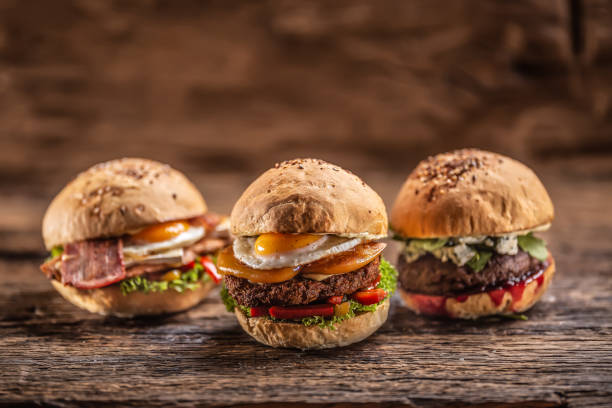istock Cheeseburger, chicken burger and beef burger with blue cheese and cranberry sauce in a rustic surroundings. 1244497245