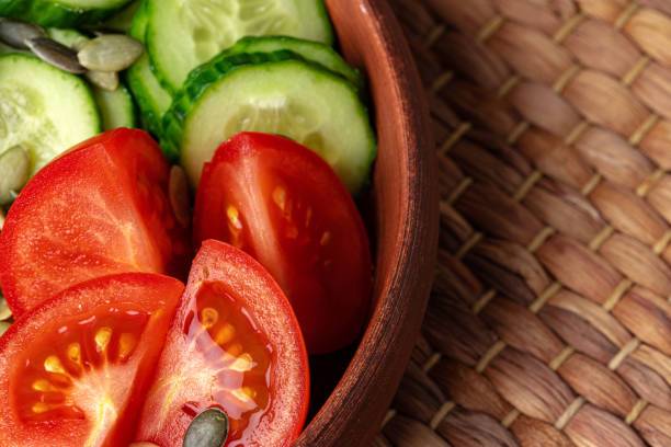 istock Ceramic bowl of tomato and cucumber salad on table 1244501124