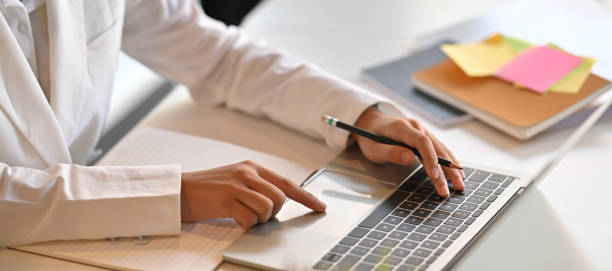 istock Hands of a businesswoman are taking notes while working with a computer laptop that putting on a white working desk surrounded by office equipment. 1244502209