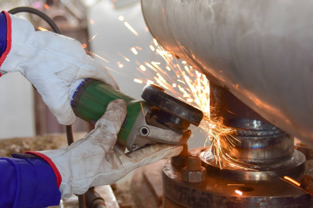 woever broie le tuyau d’acier avec un broyeur électrique. - flange grinder grinding pipe photos et images de collection