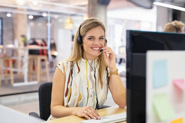 operador de centro de llamadas sonriente en el escritorio - bluetooth headset women hands free device fotografías e imágenes de stock