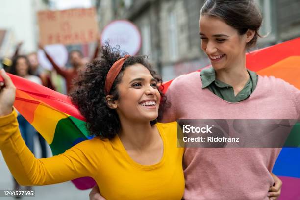Lesbian Couple At Gay Pride With Rainbow Flag Stock Photo - Download Image Now - LGBTQIA Rights, LGBTQIA People, LGBTQIA Pride Event