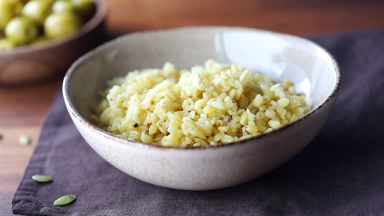 Macro footage of ceramic bowl with freshly brewed bulgur. Healthy nutrition, vitamin cereals.