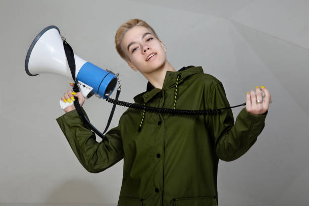 istock girl speaks on a megaphone. stylish clothes 1244550068