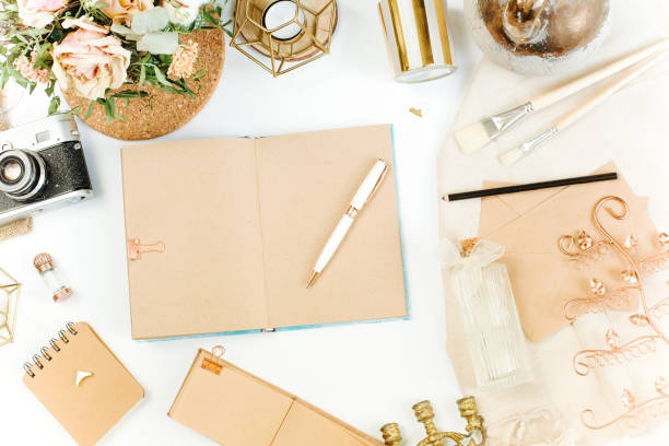 istock An elegant workspace of creative man in vintage style with notebook, film camera, envelope, candlestick, vase, flowers. Flat lay, top view 1244565461