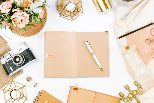 istock An elegant workspace of creative man in vintage style with notebook, film camera, envelope, candlestick, vase, flowers. Flat lay, top view 1244565507
