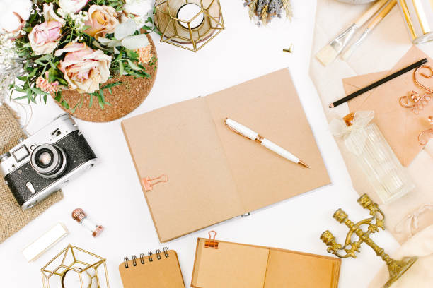 istock An elegant workspace of creative man in vintage style with notebook, film camera, envelope, candlestick, vase, flowers. Flat lay, top view 1244566056