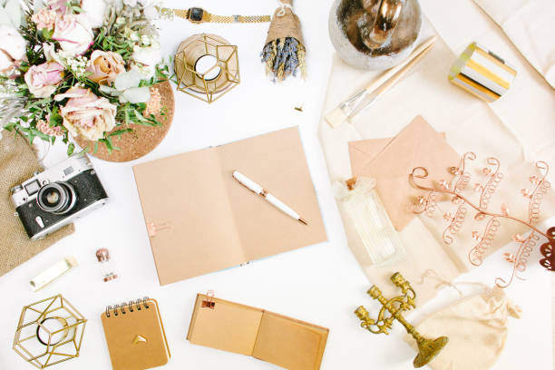 istock An elegant workspace of creative man in vintage style with notebook, film camera, envelope, candlestick, vase, flowers. Flat lay, top view 1244566062