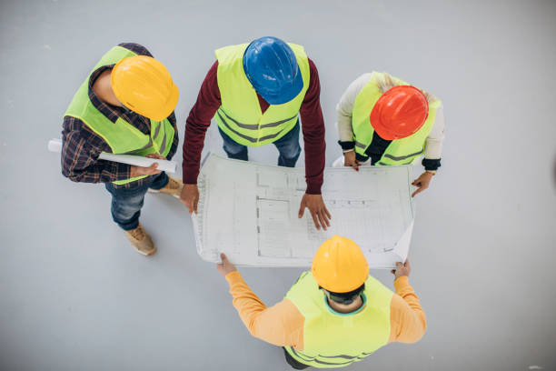 istock Group of architects and engineers looking at blueprint on a construction site indoors 1244572819