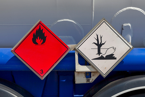 Dangerous goods signs on a tank truck side. The red placard indicate that the good transported is a Flammable Liquid and the one that it is also an Environmentally Hazardous Substance.