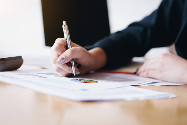 istock Businesswomen analyzing data financial reports on wooden table. 1244638959