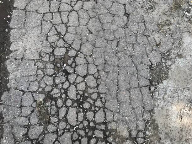 istock background texture plot of old city road smashed by car wheels into set small pieces of grey with black contour of wet earth 1244640757