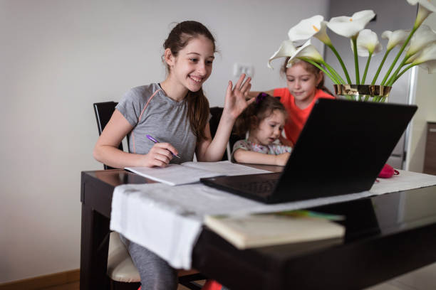 istock Happy children using laptop  for homework 1244645339