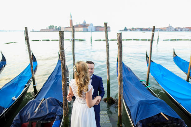 istock beautiful wedding couple posing on dock near blue gondolas 1244650835