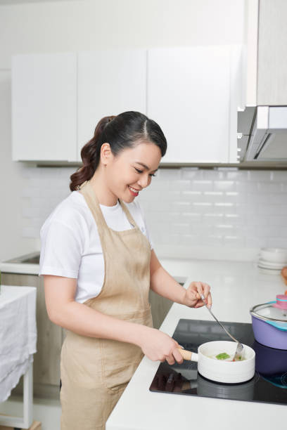 istock young woman is tasting her cooking in the kitchen 1244655538