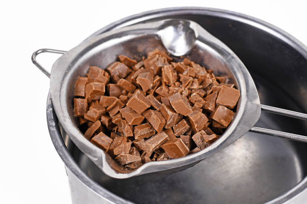 istock Chocolate pieces for baking in water melting bowl in pot on white background 1244662511