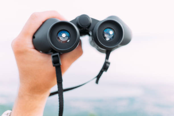 istock Male hand with binoculars outdoor, pov. 1244674296