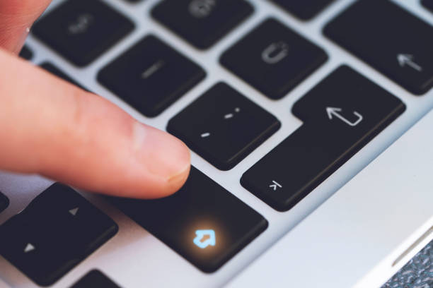 istock Closeup of Man's Finger Touching the Letter Shift Key button on Black Computer Keyboard 1244678670