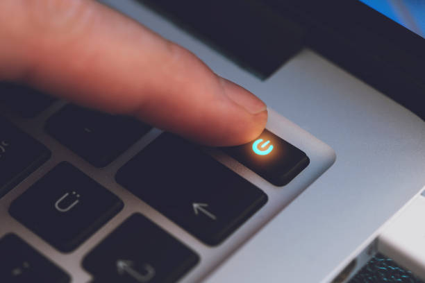 closeup of man's finger touching the letter power key on black computer keyboard - pushing push button human hand human finger imagens e fotografias de stock