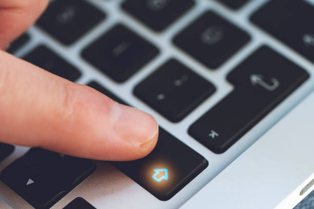 istock Closeup of Man's Finger Touching the Letter Shift Key button on Black Computer Keyboard 1244679246