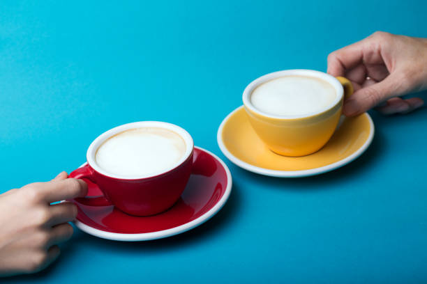istock beautiful coffee yellow and red cup with cappuccino on blue background