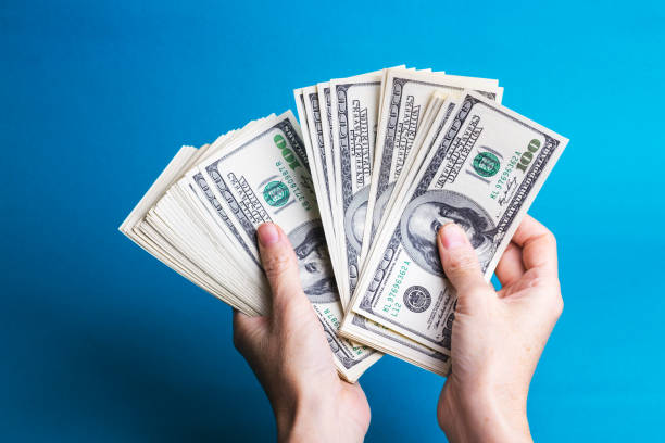 istock girl hands holding a batch of dollars