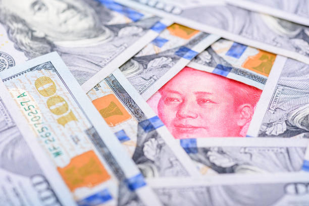 Chinese renminbi CNY 100 yuan bill and face of Mao Zedong surrounded by US USD dollar banknotes. Trade war / trade tension between China and USA, business economic concept. xi jinping stock pictures, royalty-free photos & images