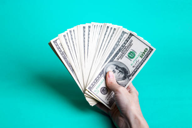 istock girl hands holding a batch of dollars