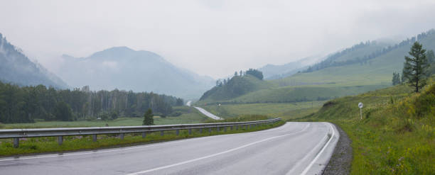 istock The road passes through a mountain valley, rainy, panoramic view 1244704614