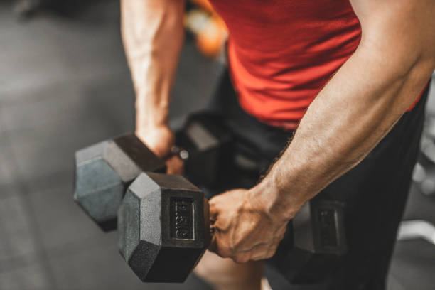 istock Unrecognizable strong man lifting weights and doing exercises for triceps at gym 1244716322
